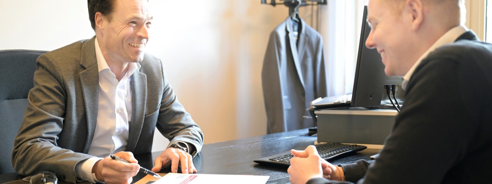 Two people reviewing paperwork together at an office desk